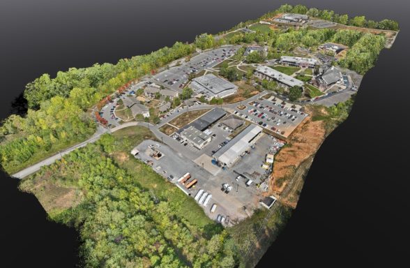 Vue aérienne d'un complexe industriel entouré d'arbres et de routes.